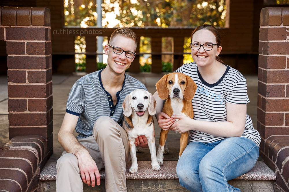 happy couple posing for photo with their two dogs